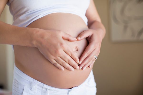 Беременная женщина с руками на животе