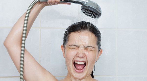 Девушка под контрастным душем, чтобы сделать кожу упругой